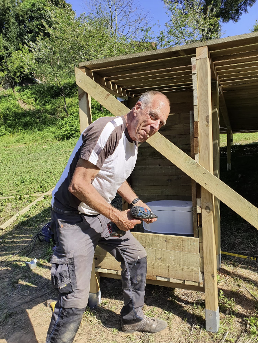Wouter Fontein aan het werk met een schroefmachine bij een houten buitenconstructie