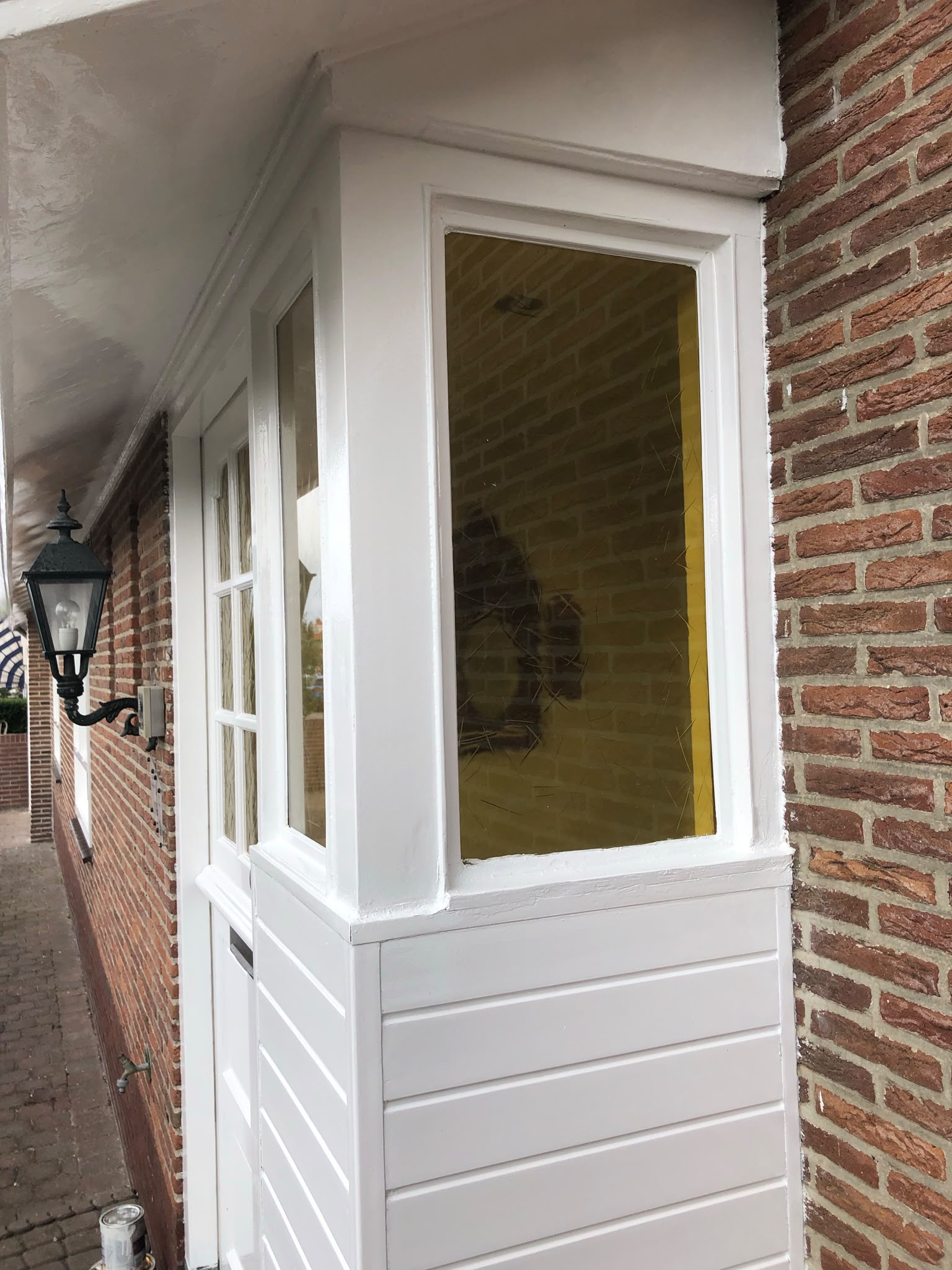 Buitenklus: net geschilderde entree met houten kozijnen